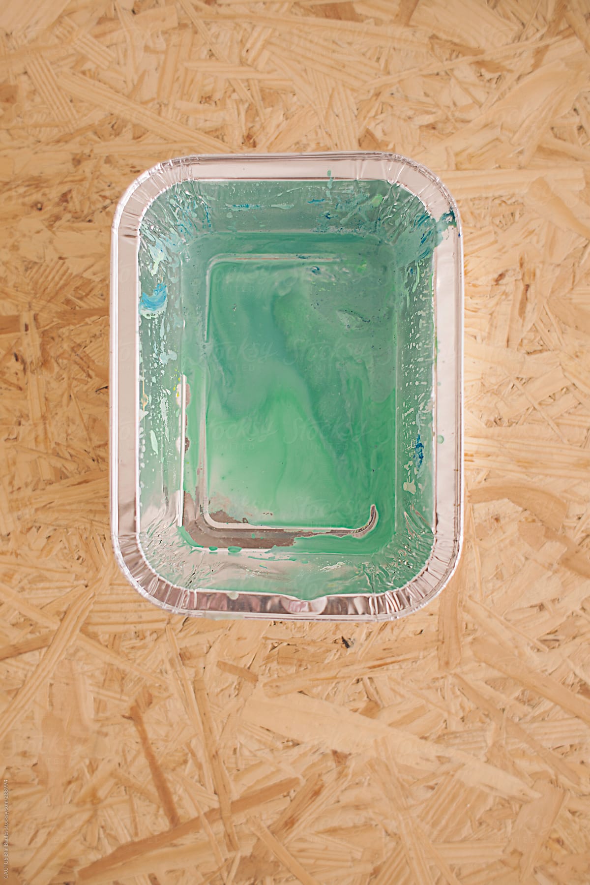 Container with green paint on a wooden table