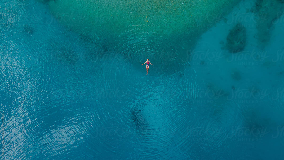 beautiful woman swim in turquoise water, drone overhead