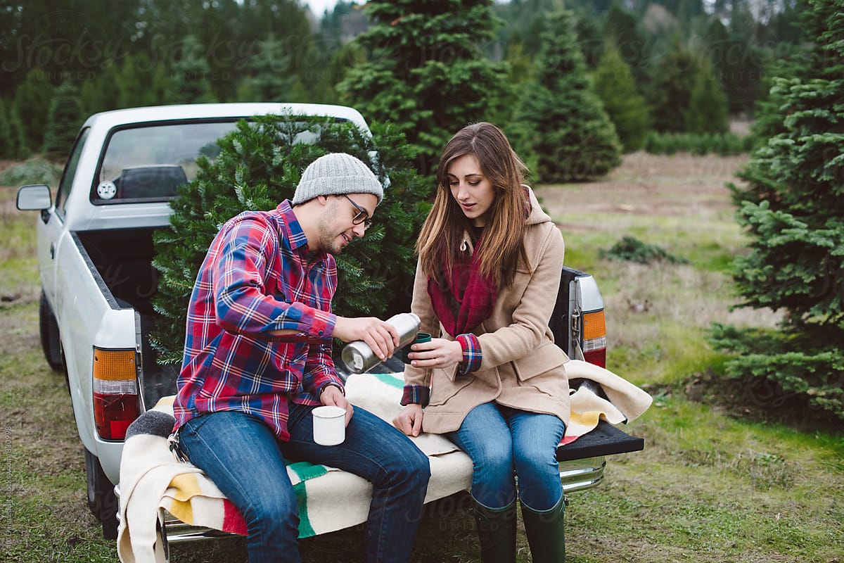 Attractive young couple at christmas tree farm in the winter.