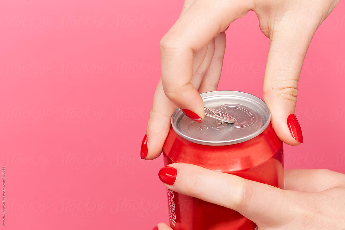 Woman with red nail varnish opens pop can