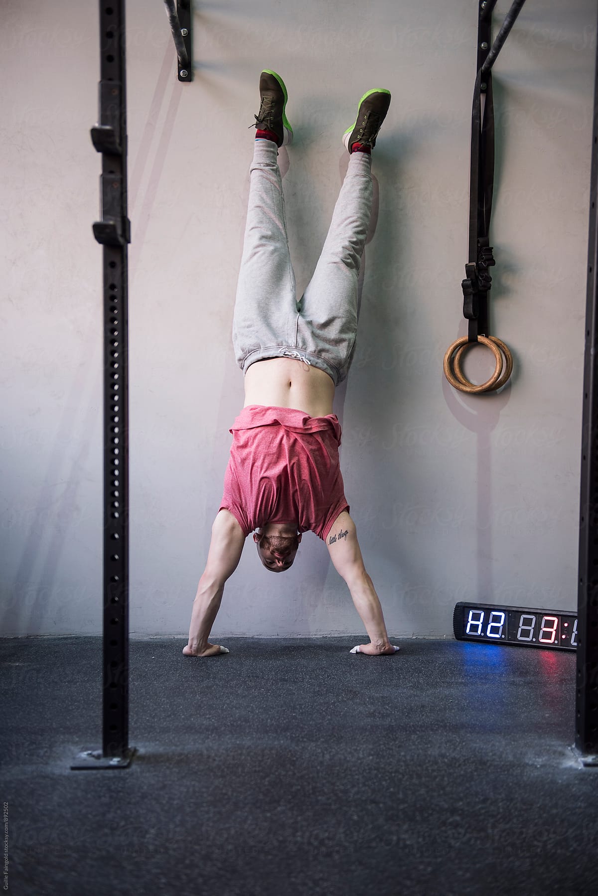 Man does handstand close to wall.