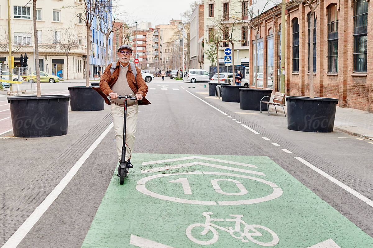 Senior man riding a scooter on street