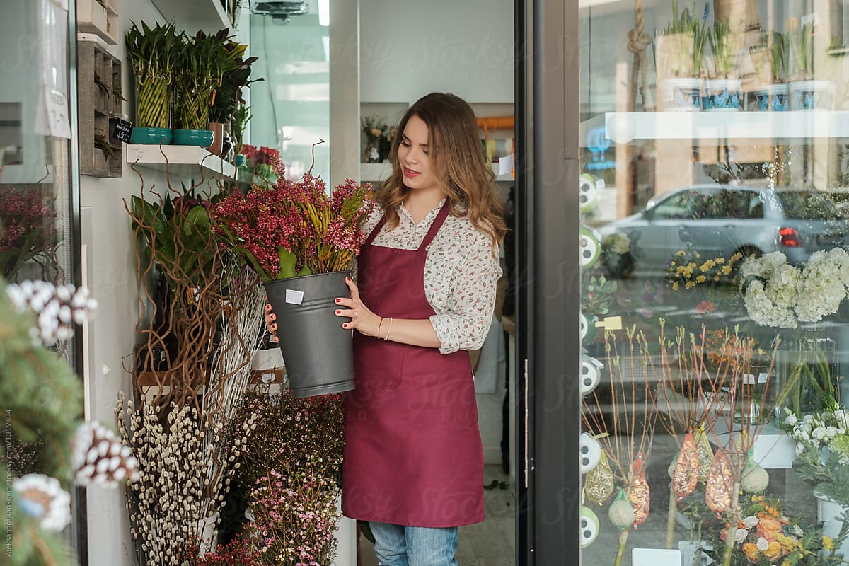 Female Florist Opening The Flower Shop