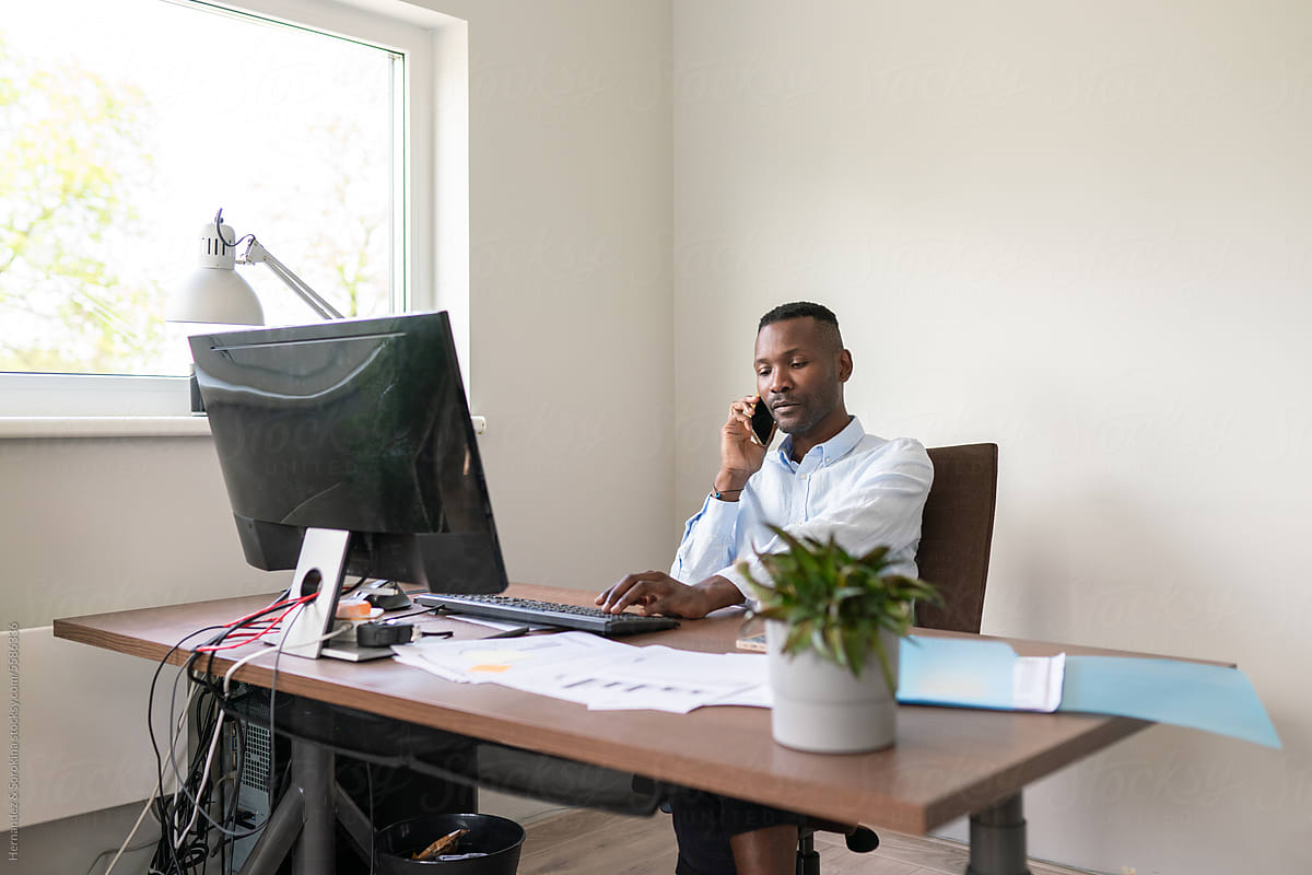 Black Man Using Phone At Office