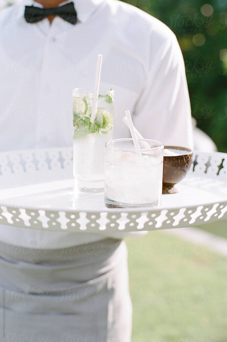 A waiter holds a tray of summer drinks/cocktails