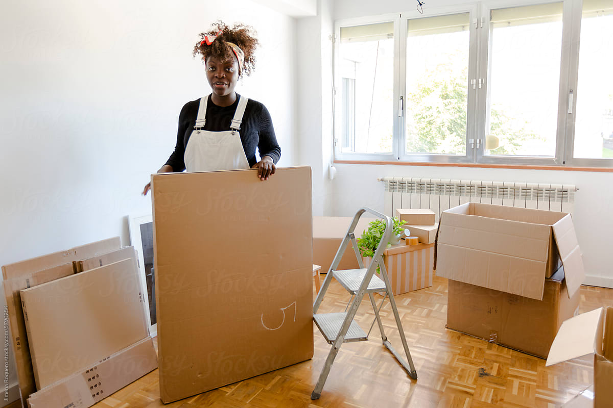 Woman moving boxes in new home living room