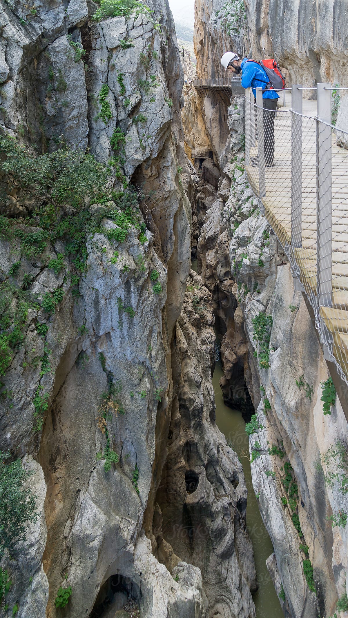 Climber looking down at the edge of a cliff in Caminito del Rey