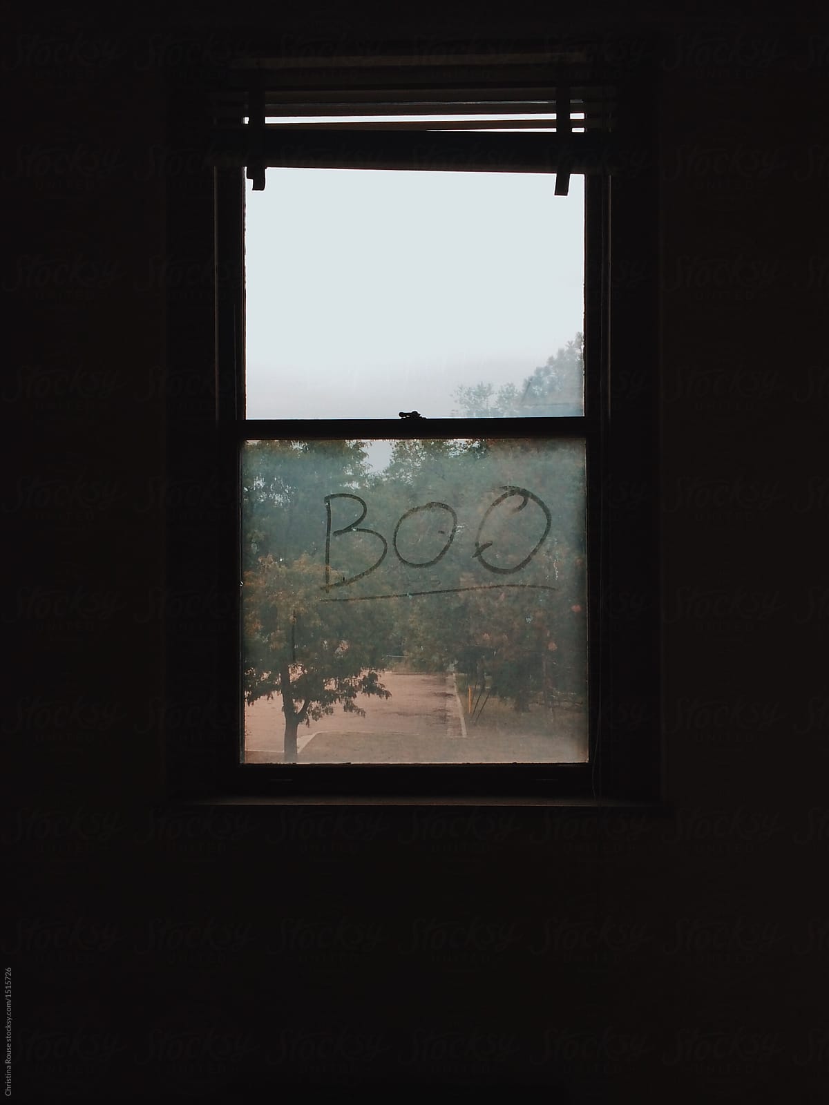 Boo written on a dirty window in an abandoned building