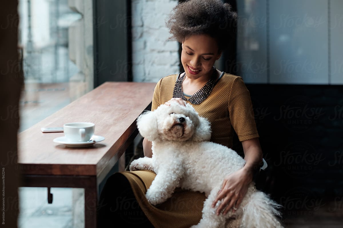 Smiling Black Woman Sitting At The Cafe With A Dog