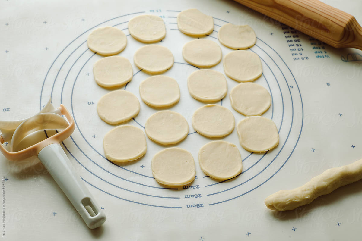 Dough circles cut for dumplings on a baking mat