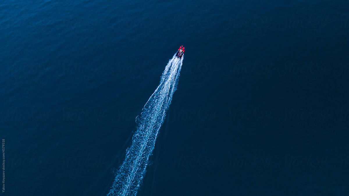 drone view of a motorboat racing in the dusk