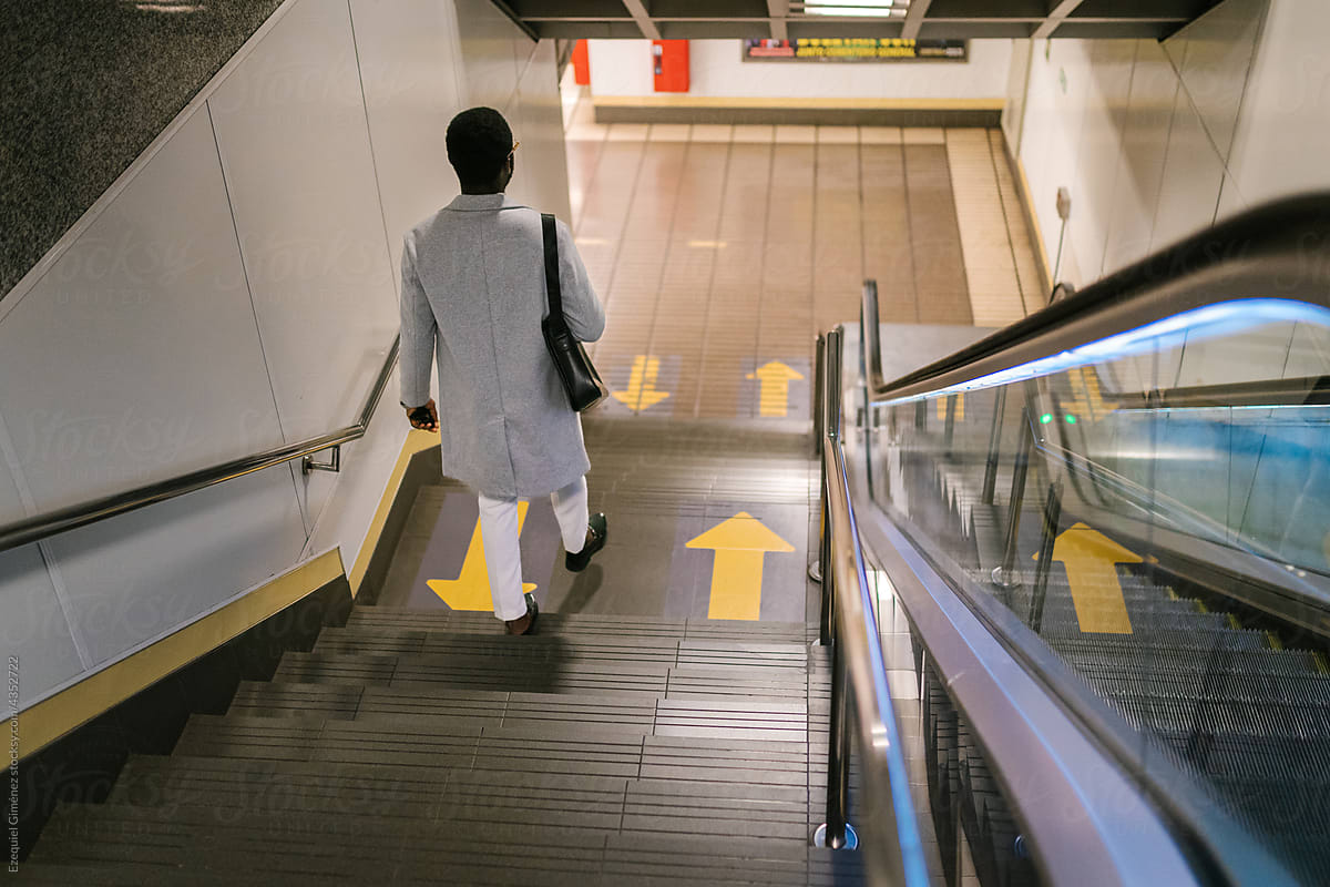 Elegant black man walking downstairs in subway