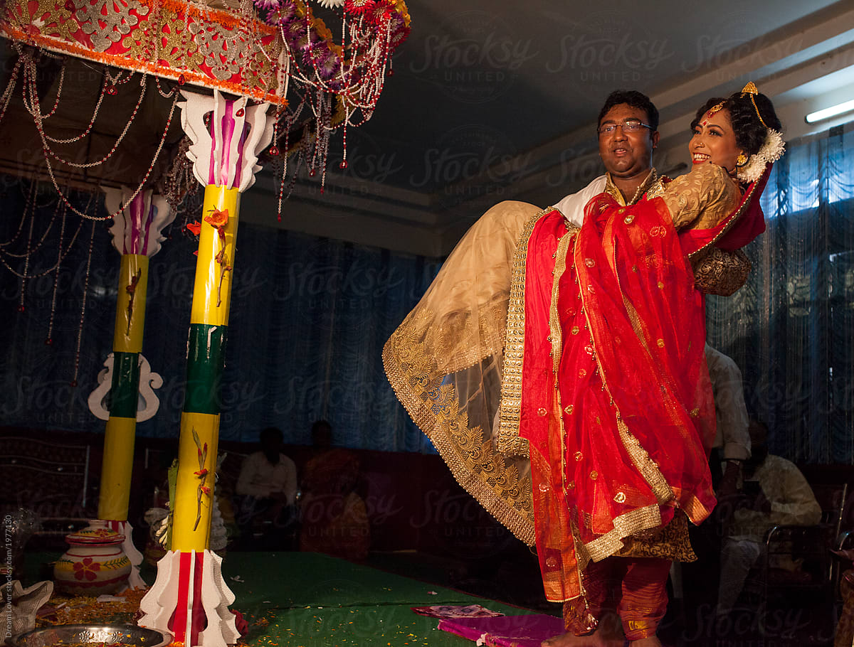 A groom picked up a bride in a marriage ceremony,enjoying and making fun