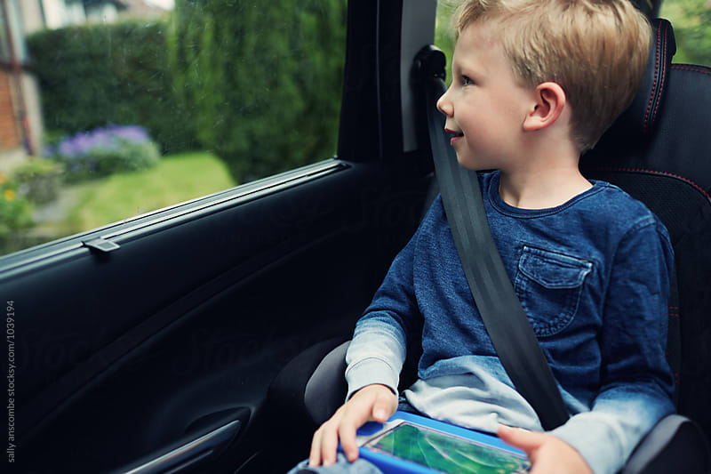 Child using an electronic tablet while in the car