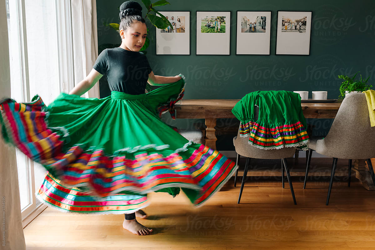 Girl dancing with traditional mexican dress at home
