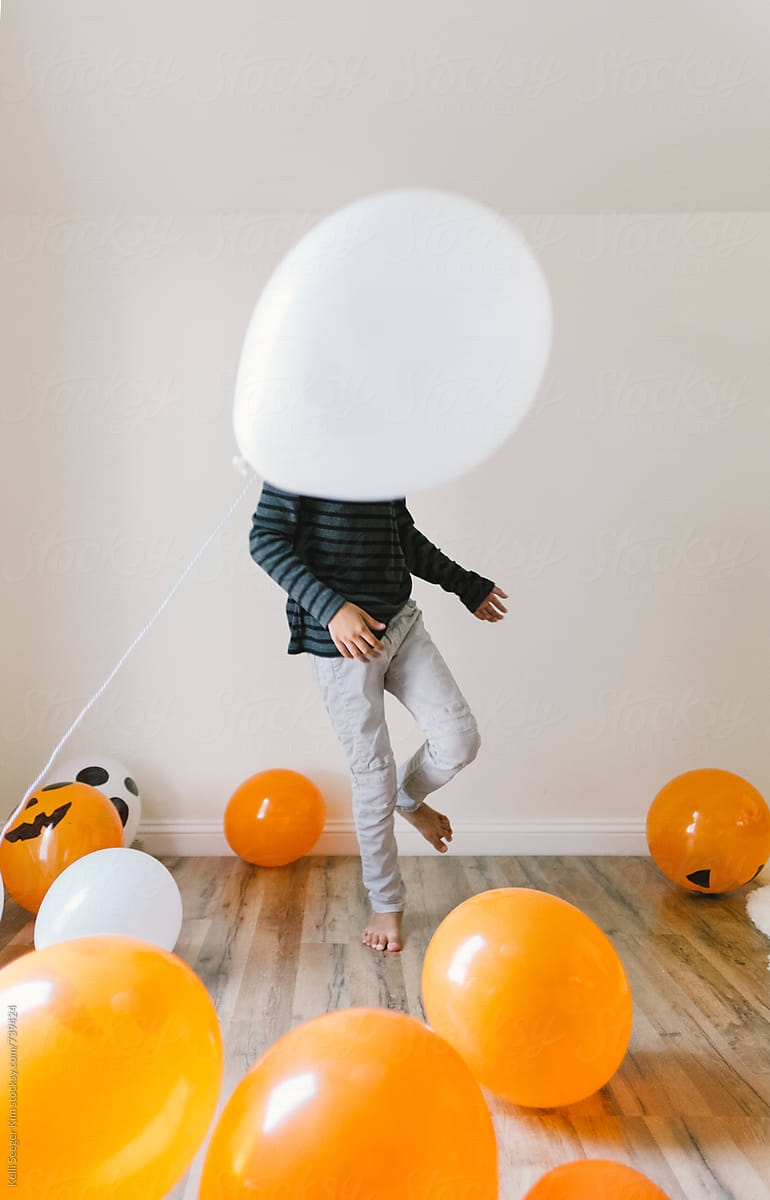 young boy plays with balloons