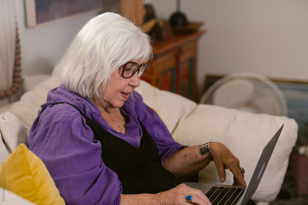 Modern mature woman with laptop at home