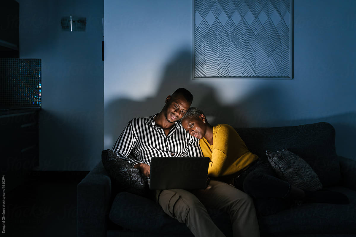 Black couple watching film at night