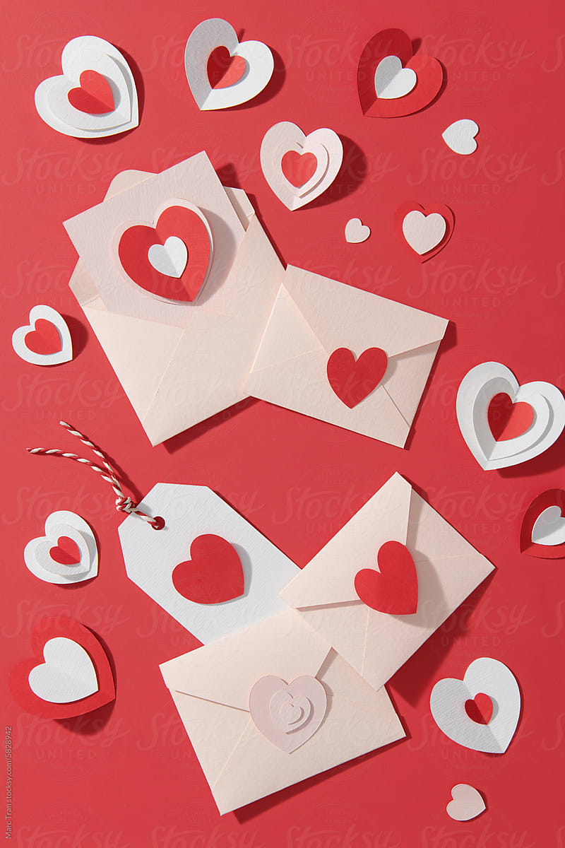 Envelopes and red - white hearts on red background. Love concept