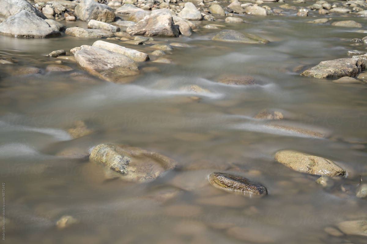 Closeup view at mountain river with rock bottom
