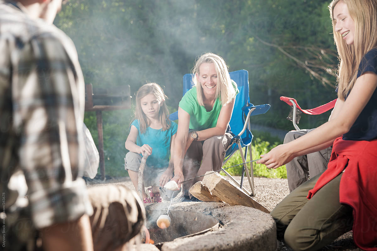 Family Roasting Marshmallows Around Campfire