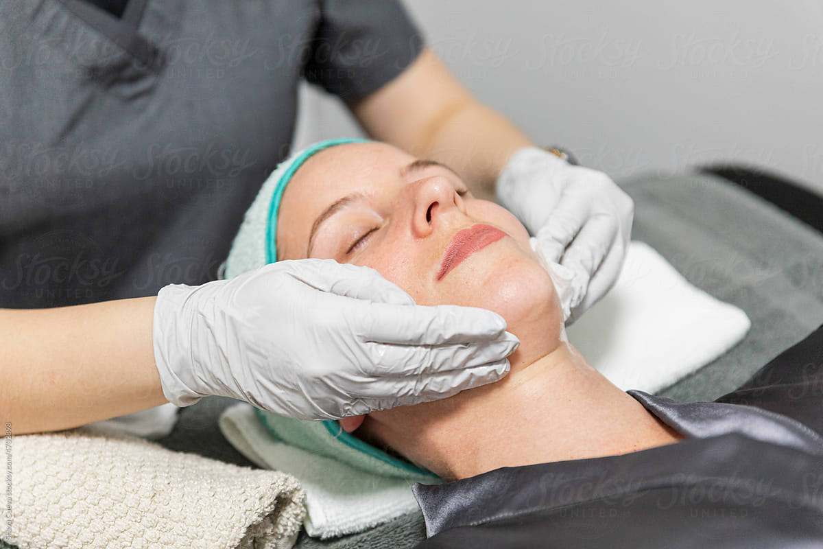 A dermatologist giving a facial massage to a woman