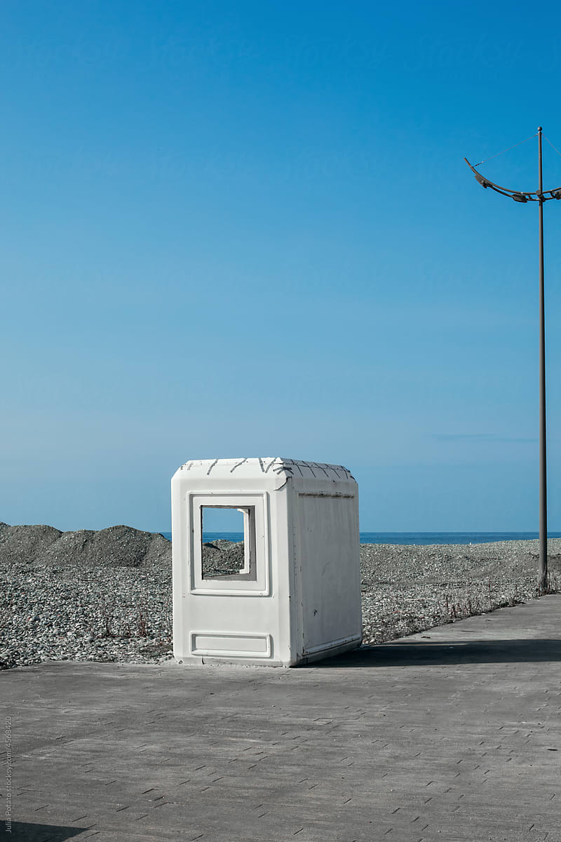 White old booth near road on the background of the sea coast