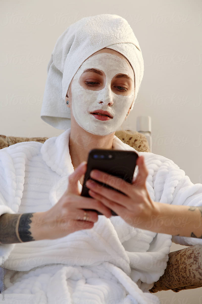 Woman with mask using smartphone