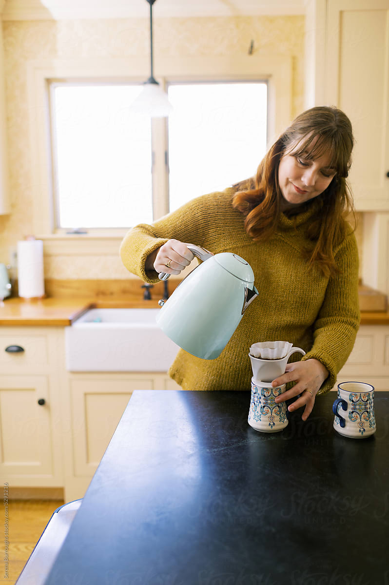 Woman preparing coffee on kitchen counter at home indoors