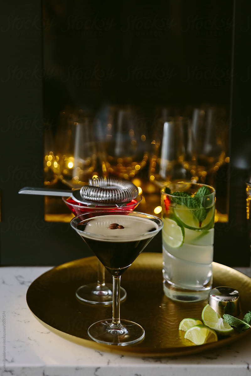 An espresso Martini on a brass tray with other mixed drinks.