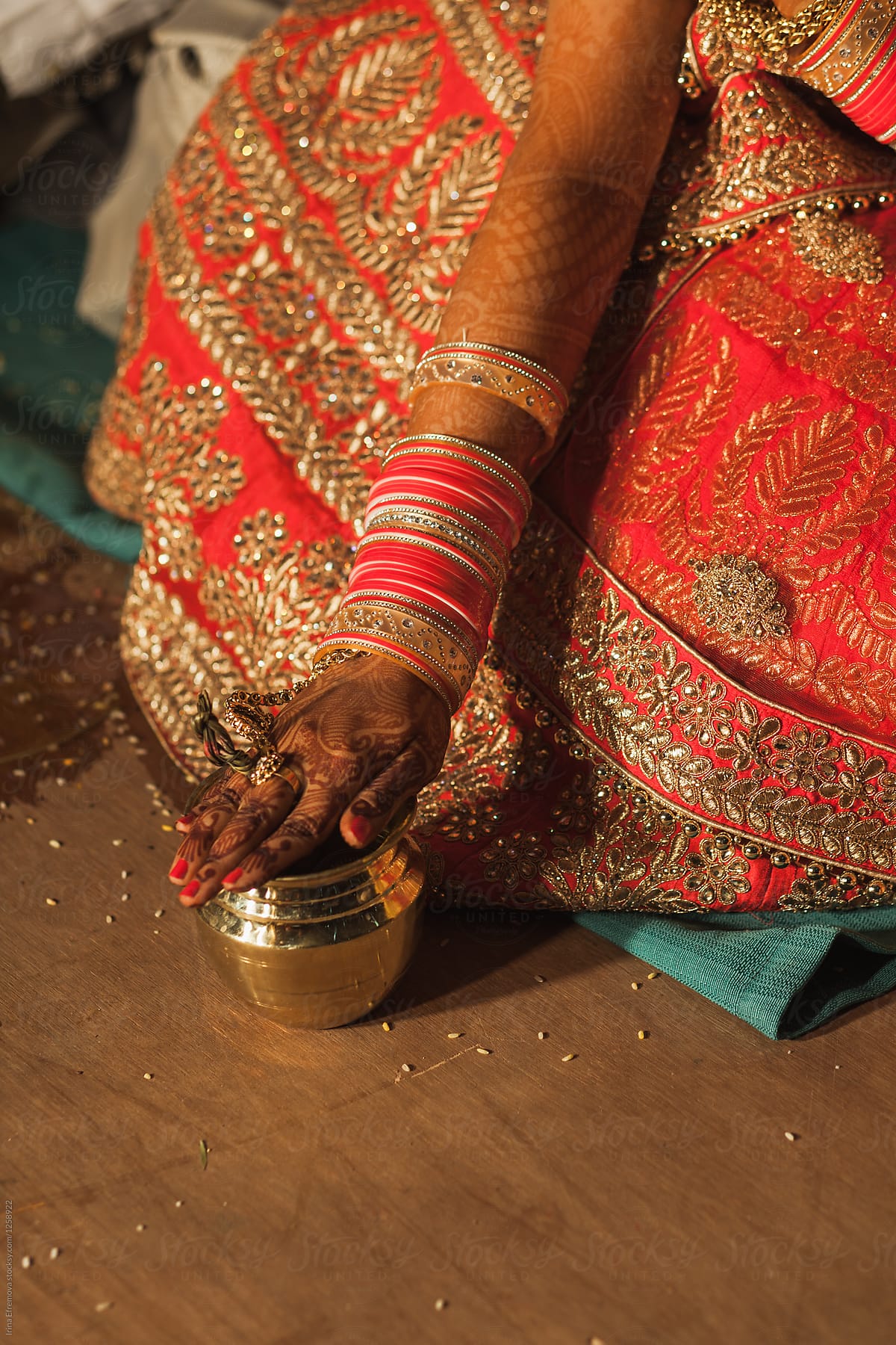 Bride\'s hand on a golden cup during a hindu wedding ceremony