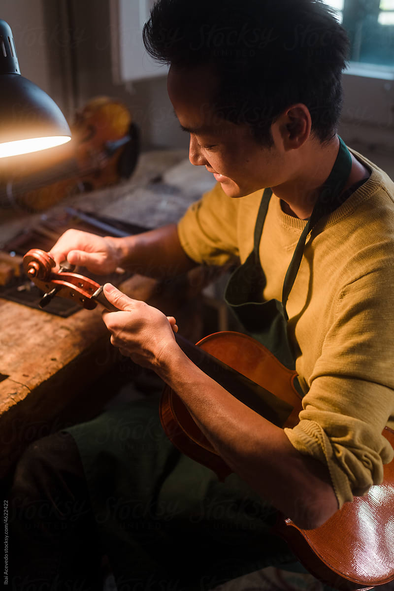 Smiling luthier working on a violin