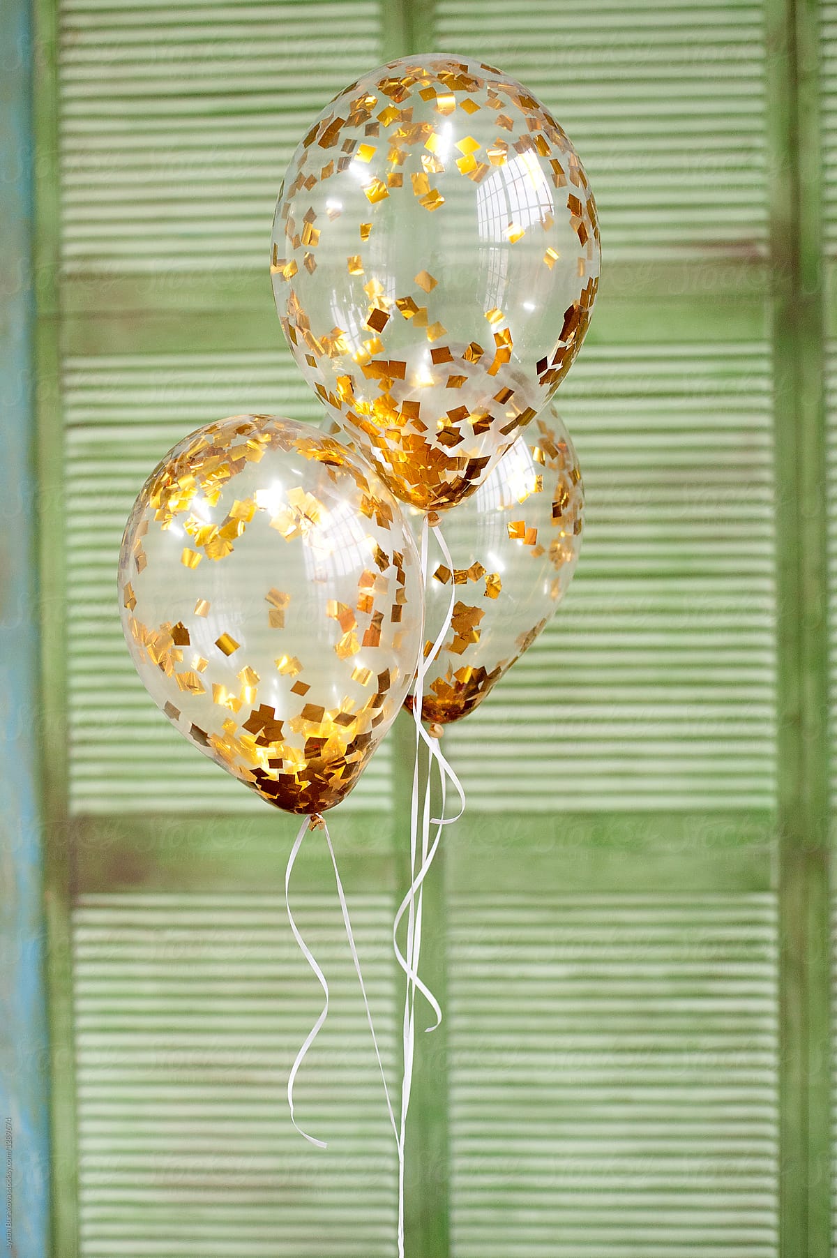 Ballons with gold confetti on green background