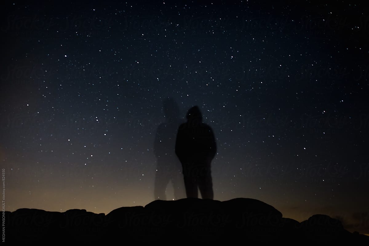 Double Silhouette of Man on Rocks at Night