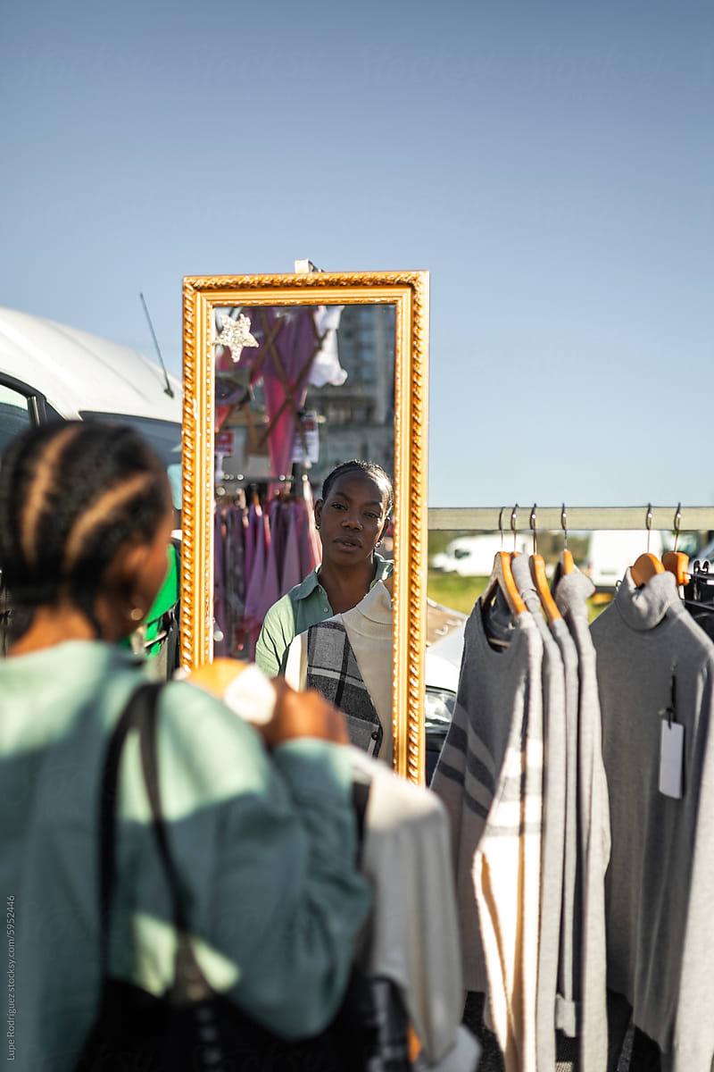 black woman buying clothes at a flea market