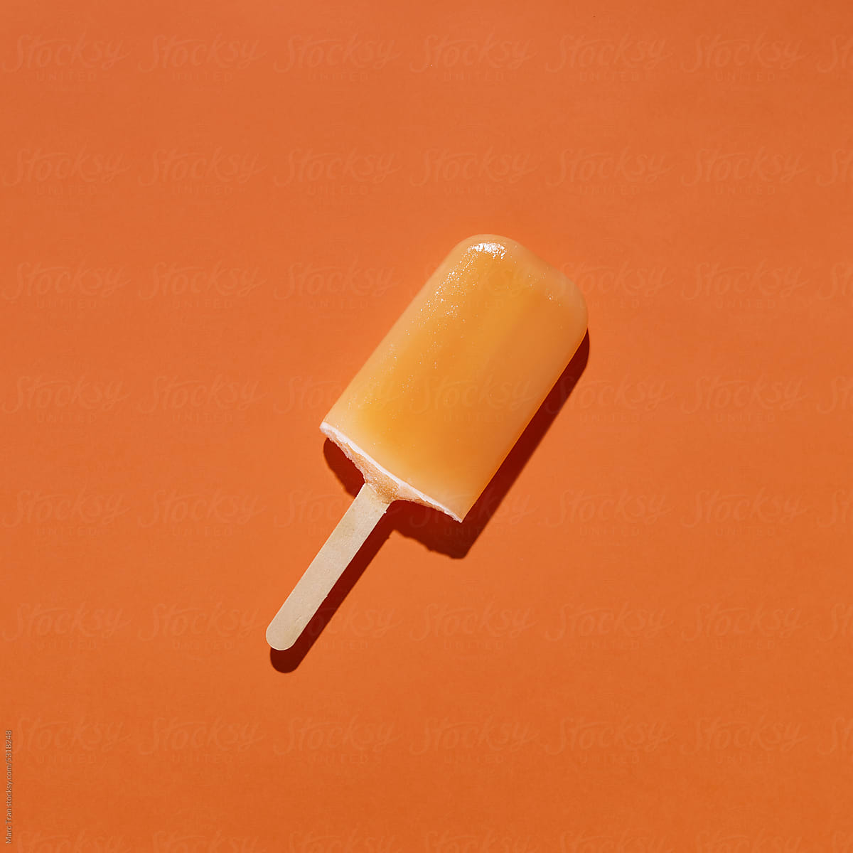 Tasty and refreshing popsicles on orange background