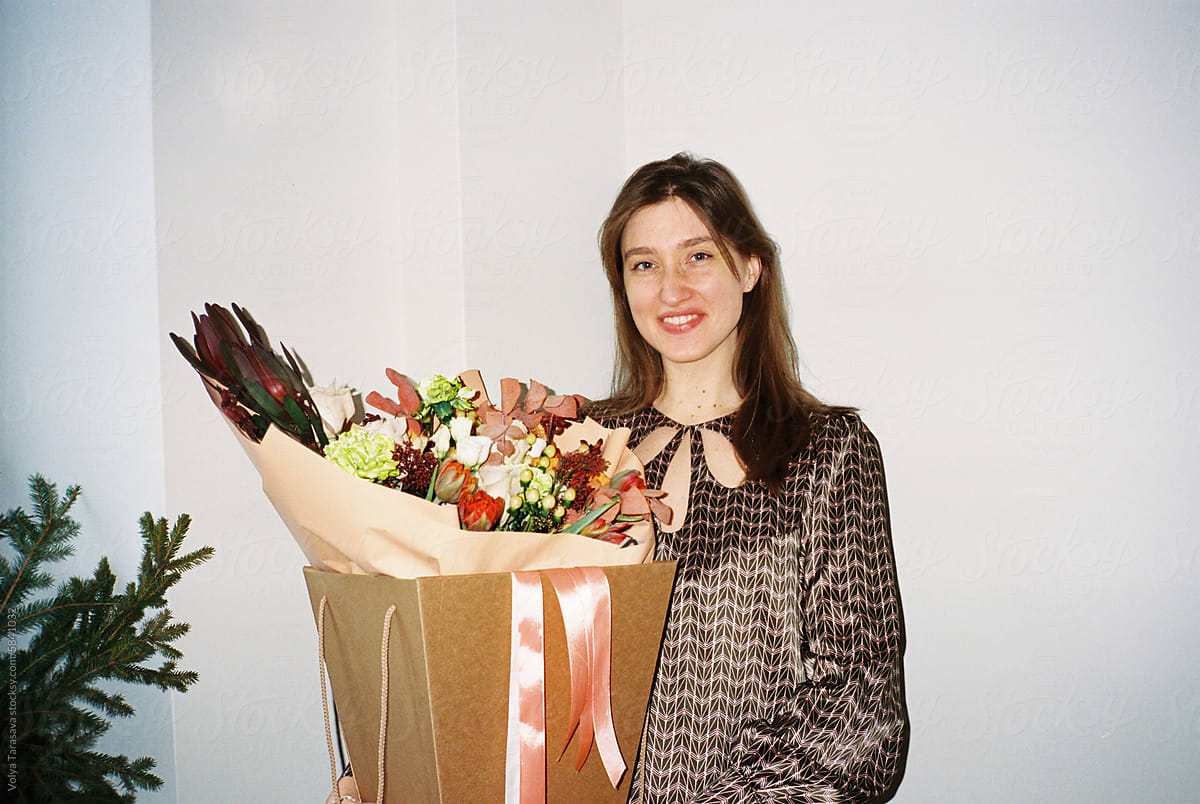 Young smiling happy woman with flowers at home