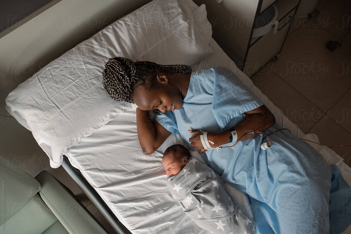 Black mom smiling near sleeping infant