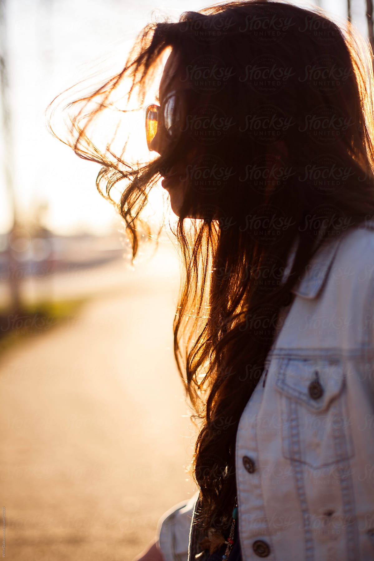 Backlit Portrait of Young Woman with Windblown Hair