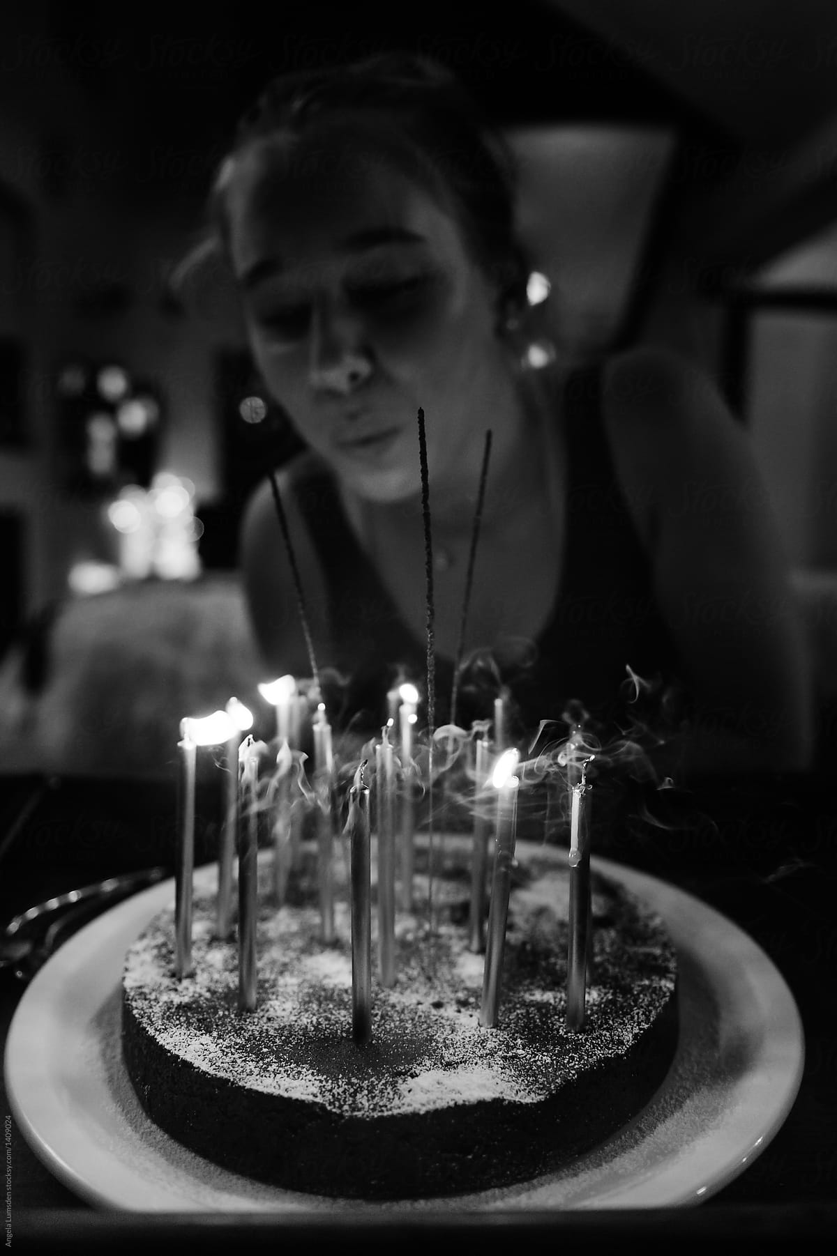 Teenage girl blowing out candles on a birthday cake