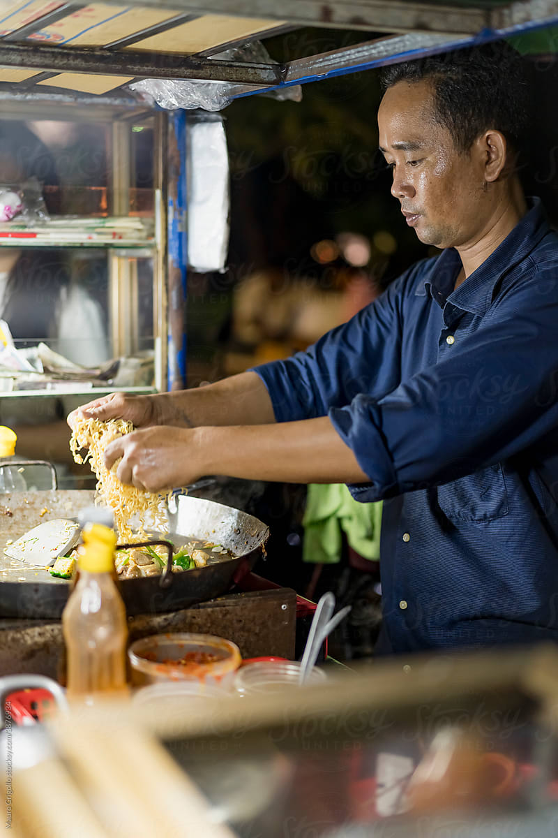 Asian chef preparing noodles
