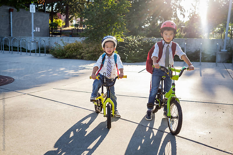 Back to school: Asian kids riding their bicycles in school