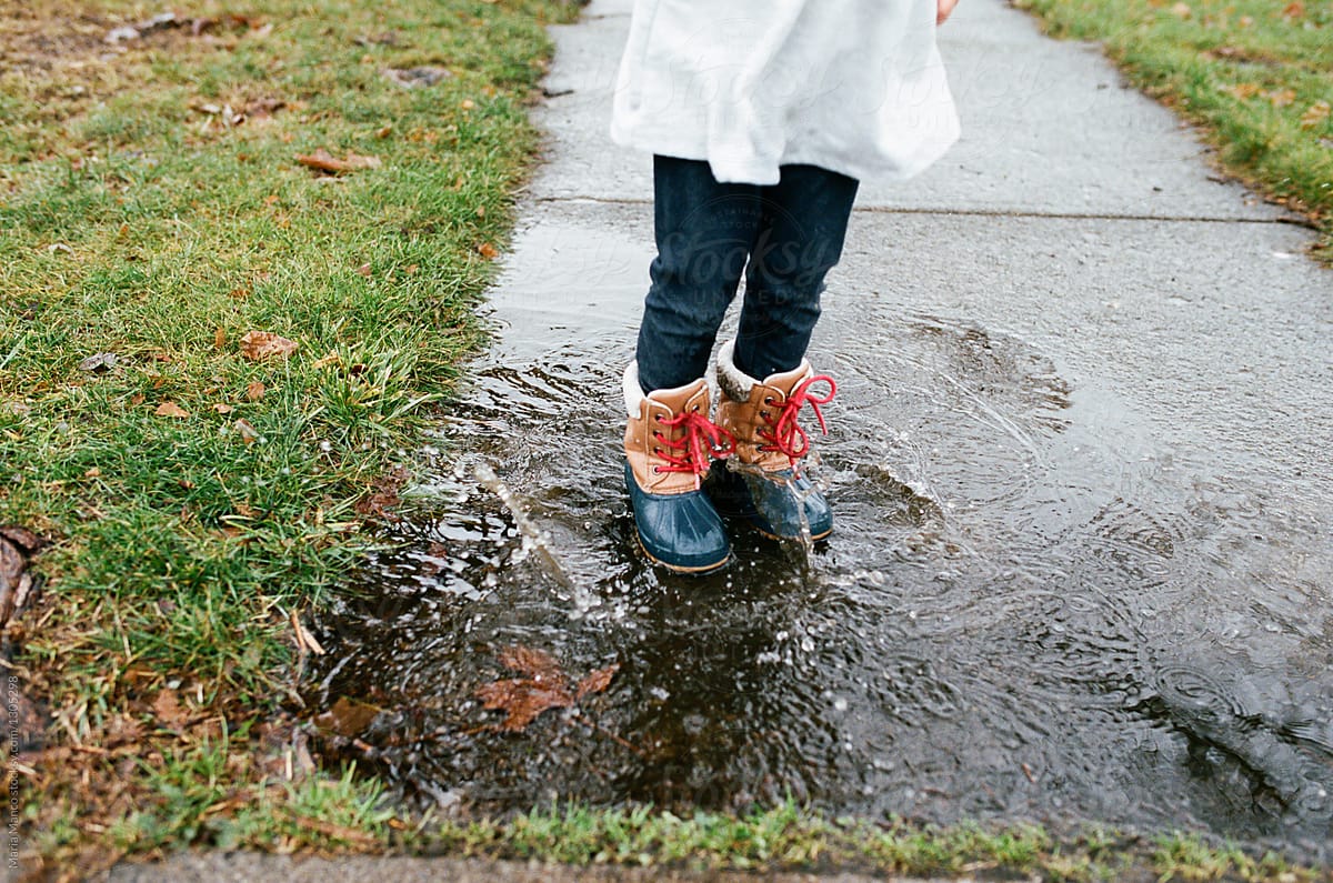 little girl jumps in puddle