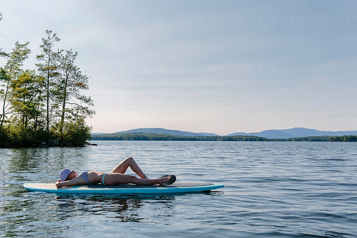 Woman Relaxing On The Lake With Stand Up Paddle Board Del Colaborador De Stocksy Raymond