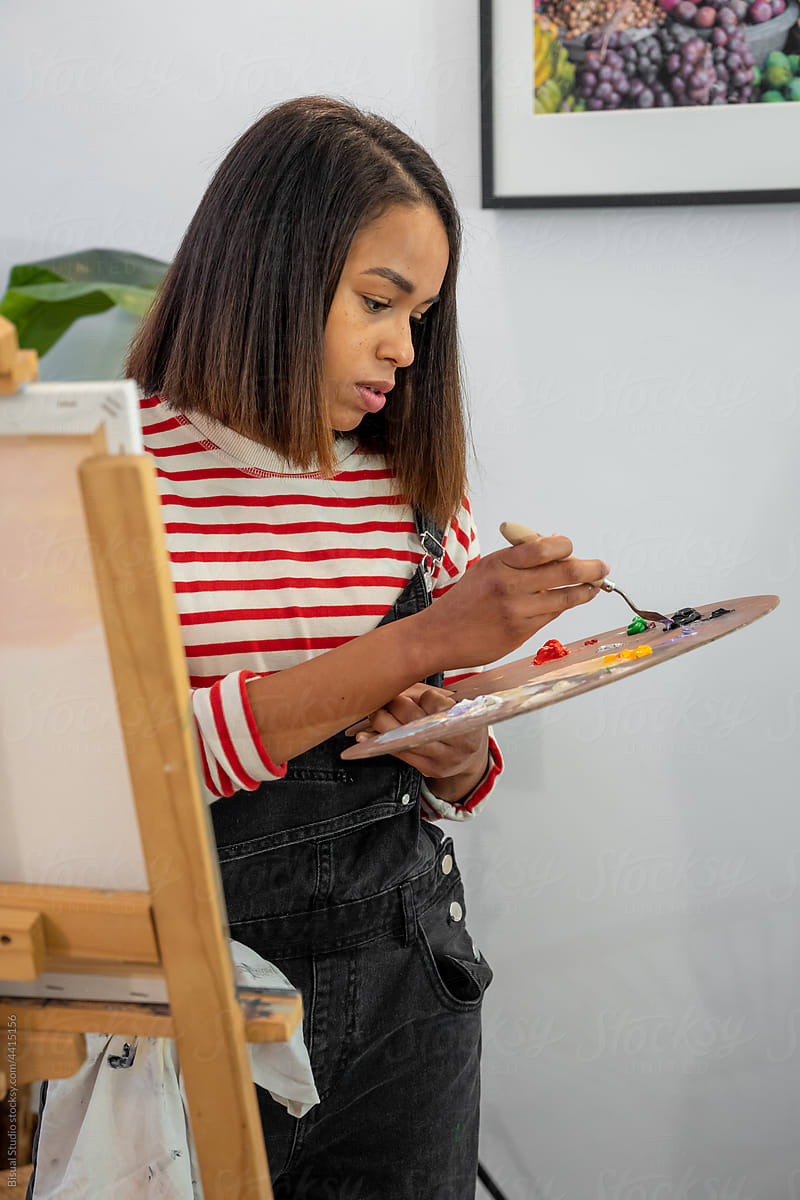 Black woman painting in art studio