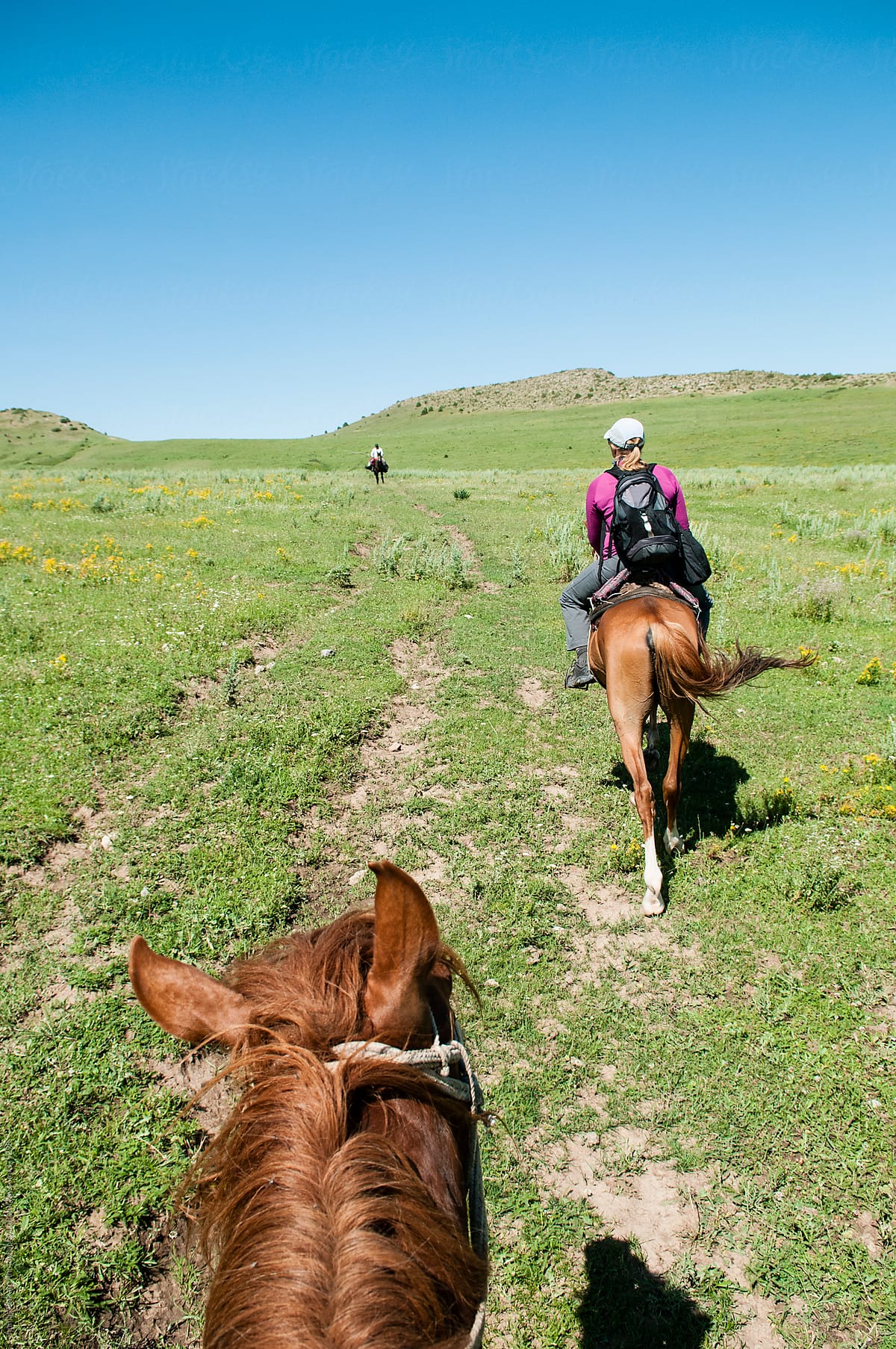 Woman horse trekking in the hills of southern Kazakhstan.