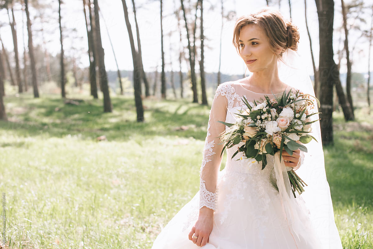 young bride with a bouquet in nature