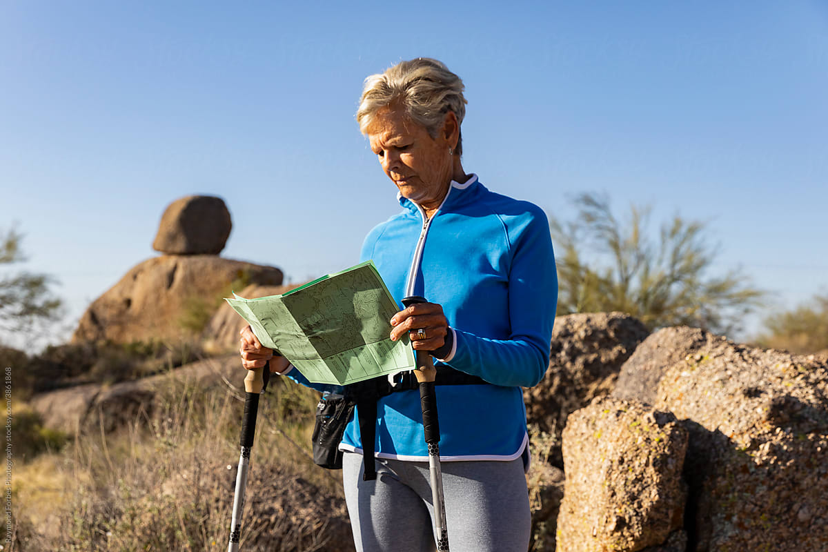 Senior Citizen Hiking in Arizona Desert and reading trail map
