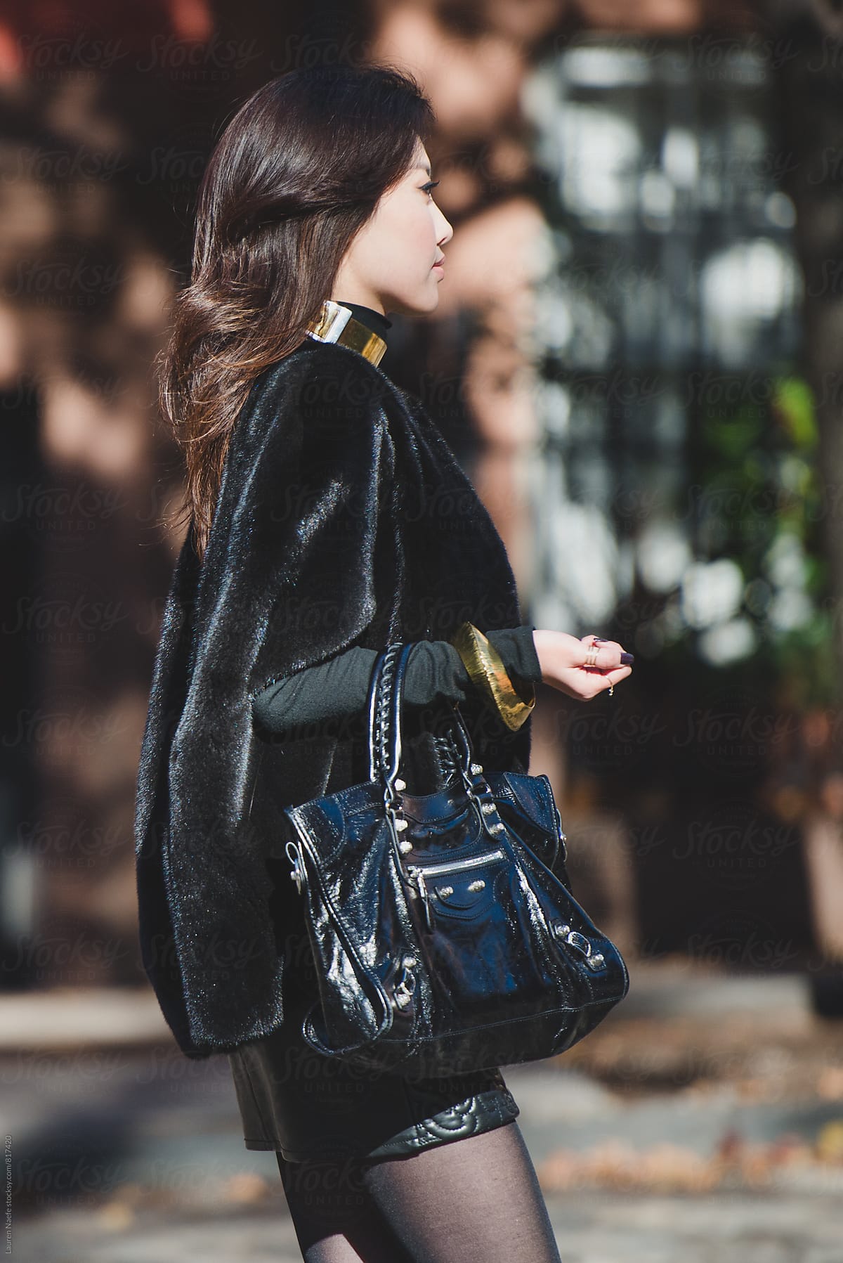 Elegant young woman walking down the street