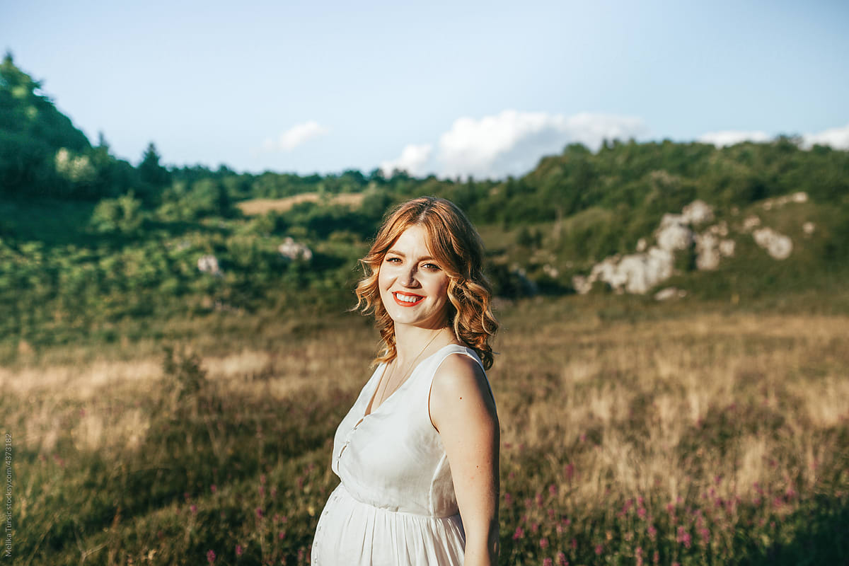 Nature portrait of a cheerful woman in a white dress